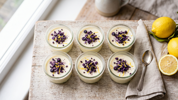 Keto lemon posset topped with crushed freeze-dried blueberries and lemon zest