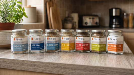 Seven Finally. sweetener jars lined up on a kitchen worktop, including Monk Fruit, Stevia, Demerara, Golden, Dark Brown, Soft Brown and Erythritol.