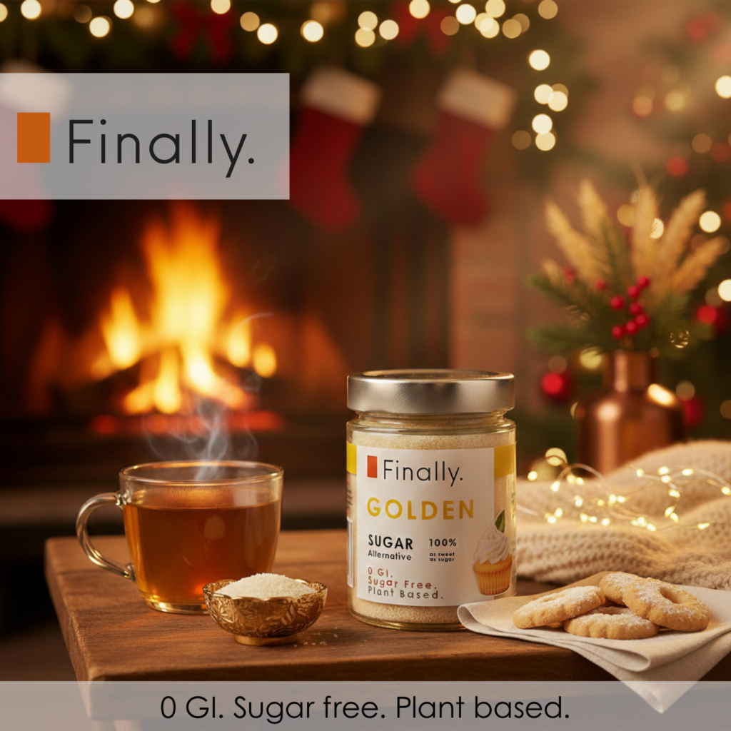 Jar of Finally Golden Sugar with a cup of tea and cookies on a wooden table in front of a fireplace and Christmas decorations.
