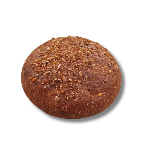 A single, round Finally Keto brown bread roll isolated against a transparent checkerboard background. The roll features a deep golden-brown crust generously topped with crushed seeds and grain fragments.